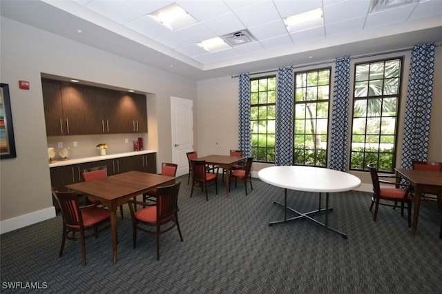 carpeted dining space featuring a tray ceiling