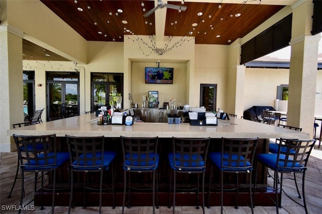 kitchen with wooden ceiling, a kitchen bar, and french doors