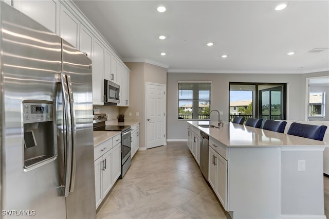 kitchen featuring sink, white cabinetry, crown molding, stainless steel appliances, and a kitchen island with sink