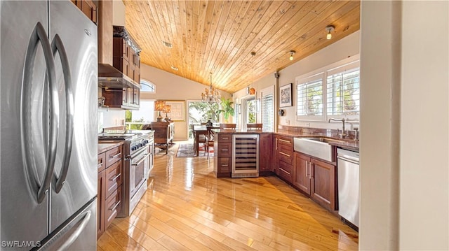 kitchen featuring sink, wooden ceiling, pendant lighting, stainless steel appliances, and beverage cooler