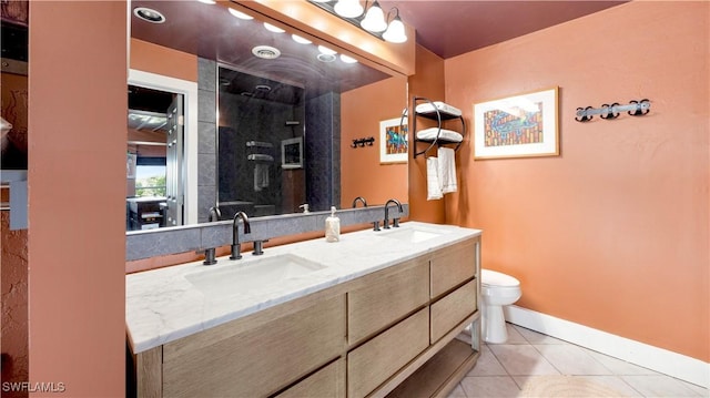 bathroom with vanity, tile patterned floors, toilet, and tiled shower