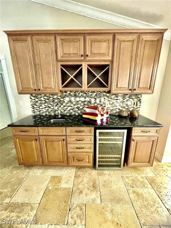 bar featuring wine cooler, sink, tasteful backsplash, and dark stone countertops