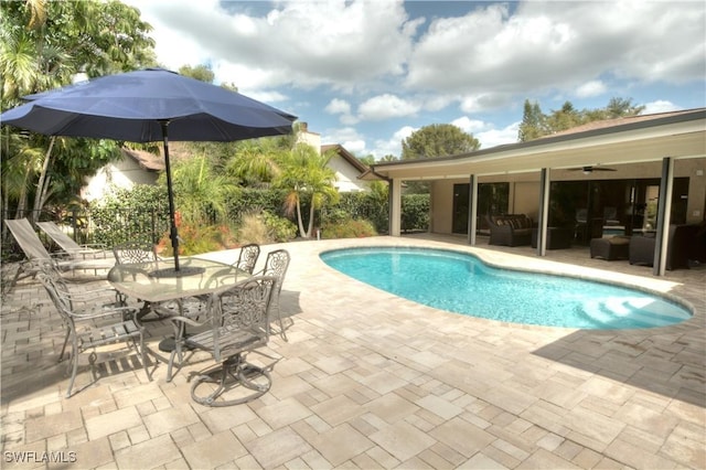 view of swimming pool with outdoor lounge area, a patio, and ceiling fan