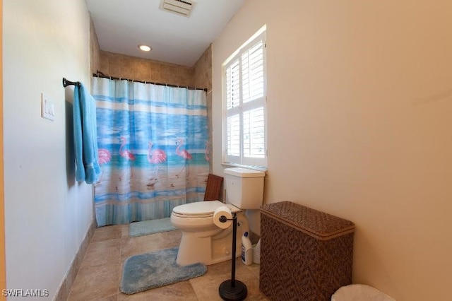 bathroom featuring curtained shower, tile patterned floors, and toilet