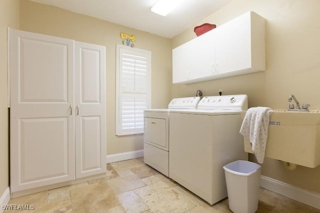 laundry area featuring cabinets, sink, and washer and clothes dryer