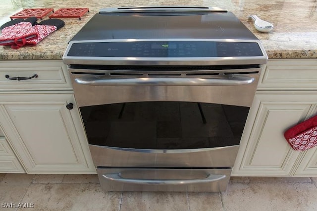 room details with stainless steel range with electric stovetop and light stone countertops