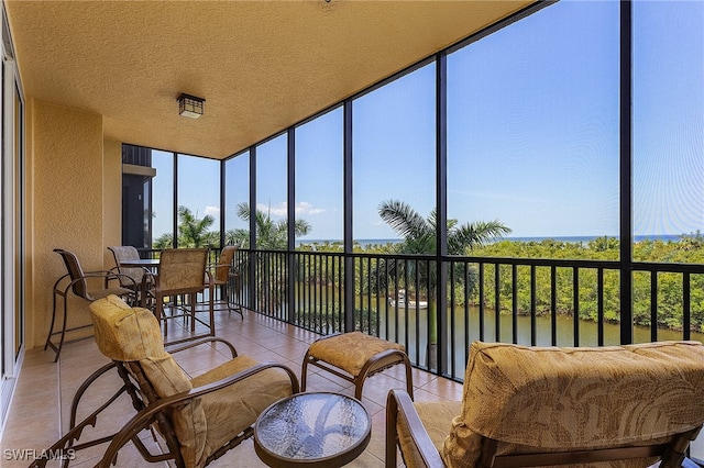 sunroom / solarium featuring a water view and a wealth of natural light