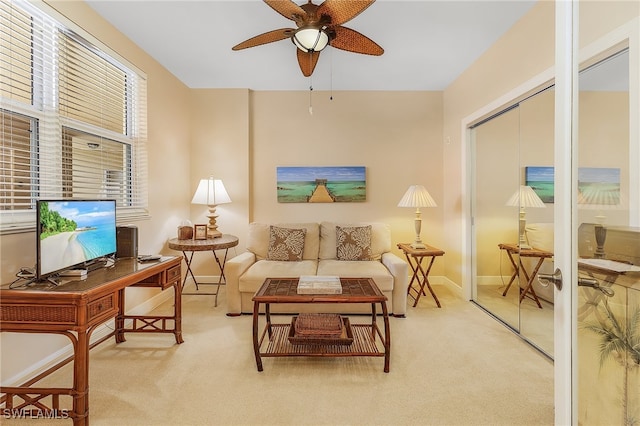 carpeted living room with ceiling fan