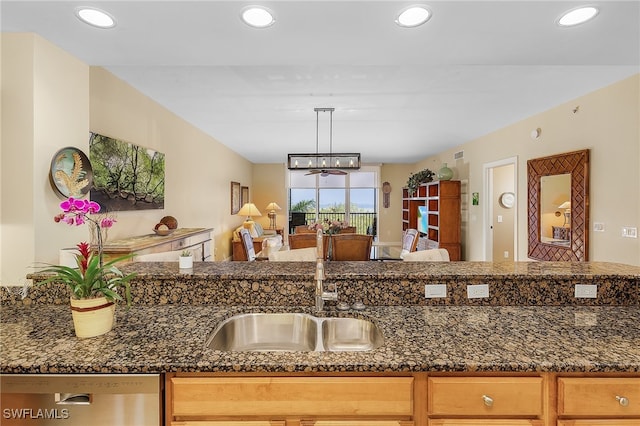 kitchen featuring dishwasher, dark stone countertops, sink, and pendant lighting