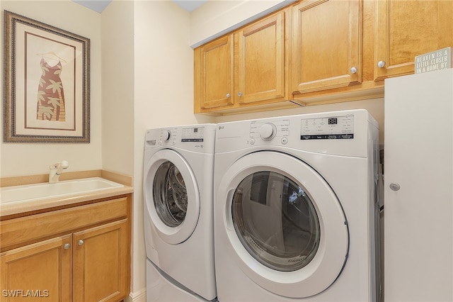 washroom with cabinets, sink, and washer and clothes dryer