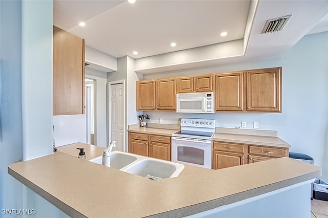 kitchen featuring sink, white appliances, and kitchen peninsula