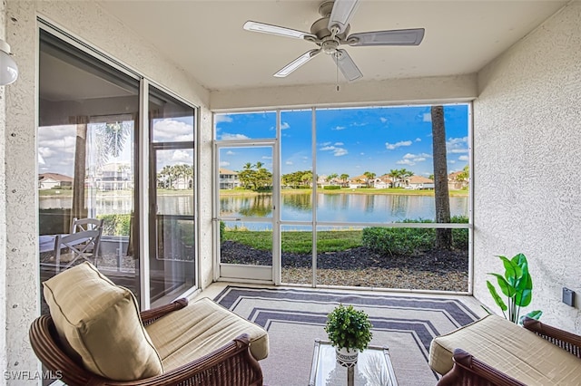 sunroom / solarium featuring a water view and ceiling fan