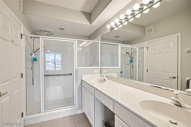 bathroom with an enclosed shower, vanity, and tile patterned floors