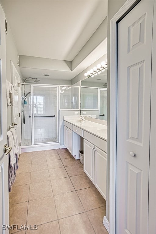 bathroom with vanity, an enclosed shower, and tile patterned flooring