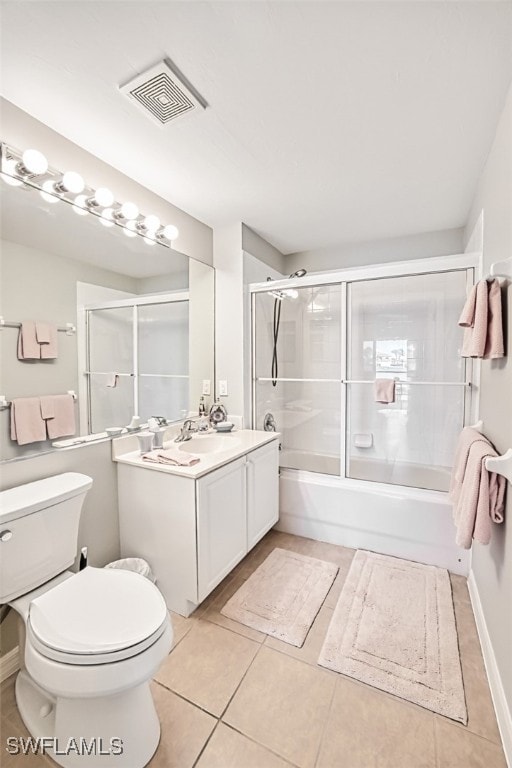 full bathroom with vanity, bath / shower combo with glass door, tile patterned floors, and toilet