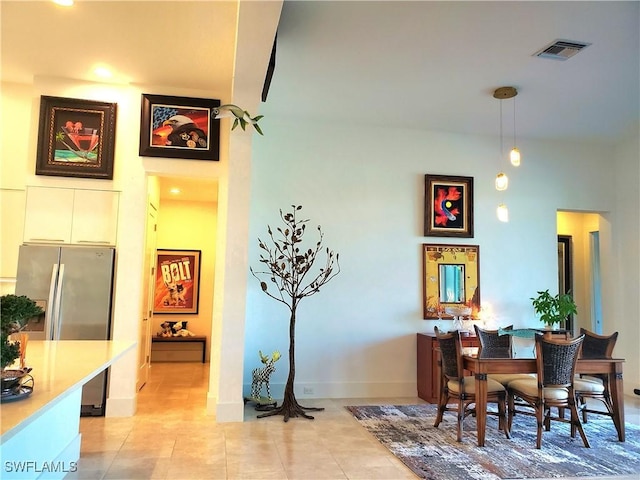 dining area with light tile patterned floors, baseboards, and visible vents