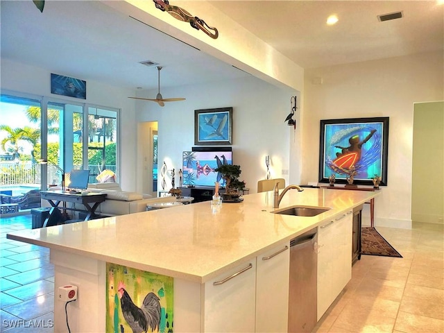 kitchen featuring a center island with sink, visible vents, open floor plan, white cabinets, and a sink