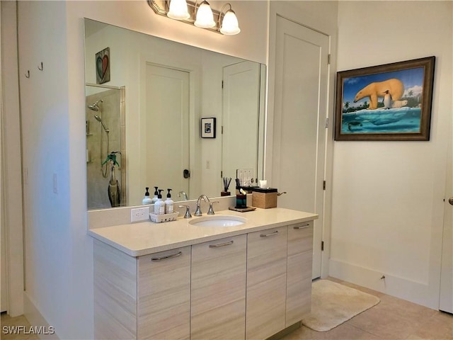 bathroom with tile patterned floors, a shower stall, baseboards, and vanity