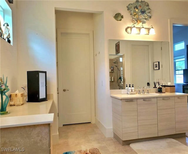 bathroom with a stall shower, tile patterned floors, baseboards, and vanity