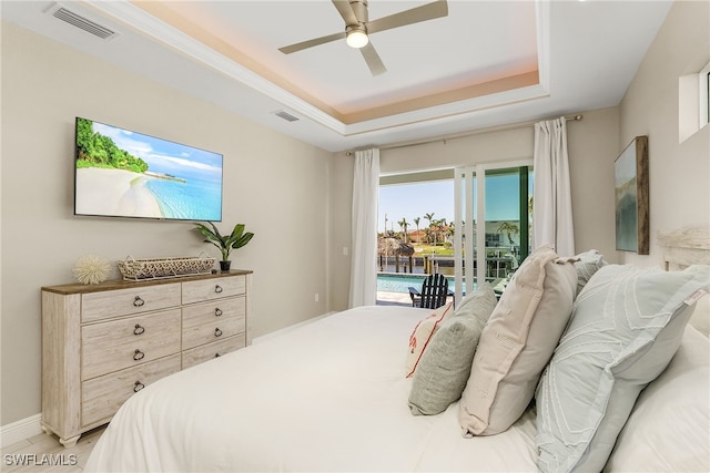 bedroom featuring access to exterior, ceiling fan, and a tray ceiling