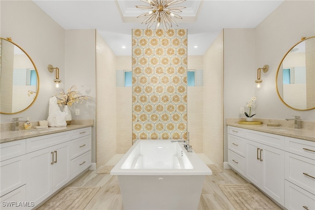 bathroom featuring vanity, a notable chandelier, and a bathtub