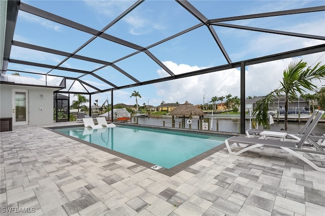 view of swimming pool with a water view, a patio area, and glass enclosure