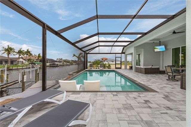 view of pool featuring a dock, an outdoor hangout area, a patio, and glass enclosure