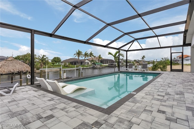 view of pool with a water view, a patio, and a lanai