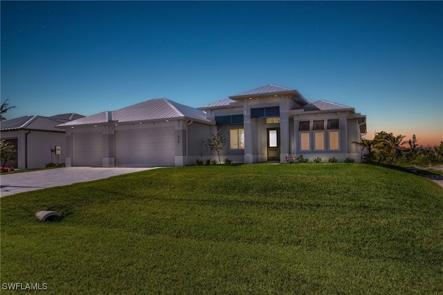 prairie-style home with a garage and a yard