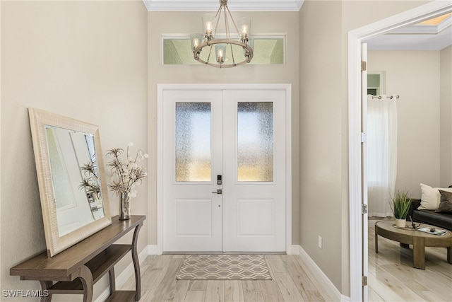 entryway featuring french doors, crown molding, a notable chandelier, and light hardwood / wood-style flooring