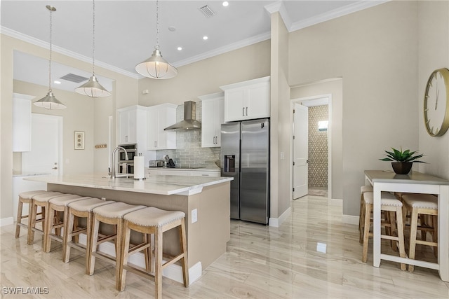 kitchen with white cabinetry, stainless steel fridge with ice dispenser, hanging light fixtures, a large island, and wall chimney range hood