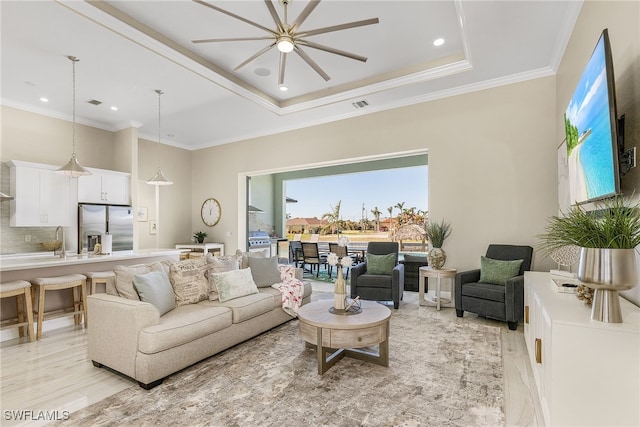 living room featuring ornamental molding, a raised ceiling, and light hardwood / wood-style floors