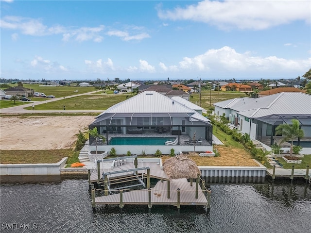 rear view of property with a water view and a lanai