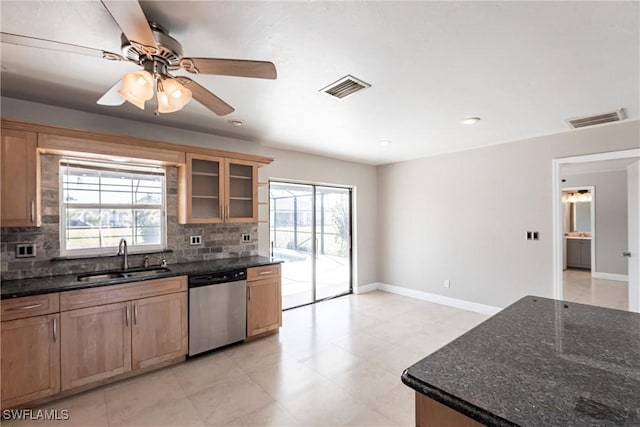 kitchen with stainless steel dishwasher, sink, decorative backsplash, and a wealth of natural light