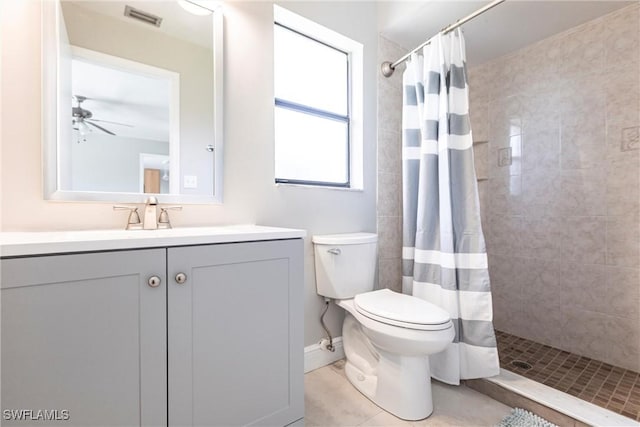 bathroom with tile patterned floors, toilet, vanity, curtained shower, and ceiling fan