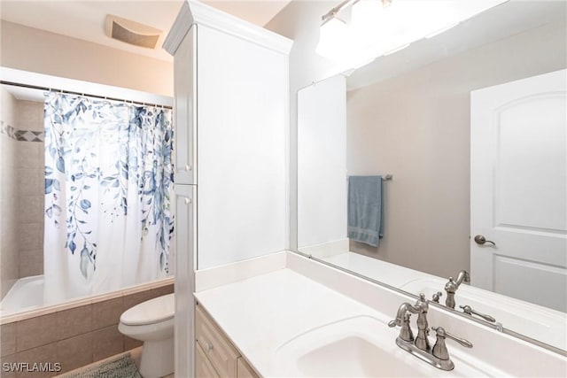 full bathroom with vanity, shower / tub combo, and toilet