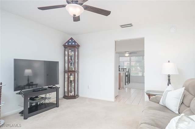 living room with ceiling fan and carpet