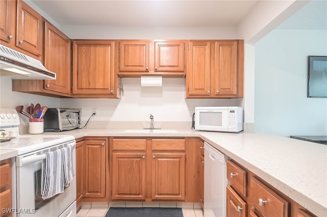 kitchen featuring sink, light stone counters, white appliances, and light tile patterned floors