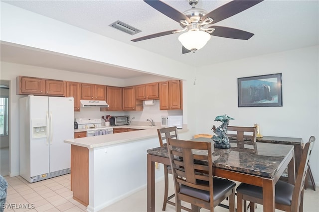 kitchen with white appliances, a textured ceiling, light tile patterned floors, kitchen peninsula, and ceiling fan