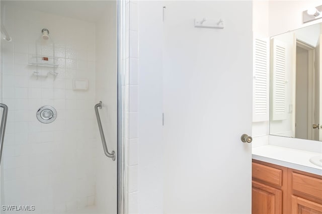 bathroom featuring vanity and a shower with door