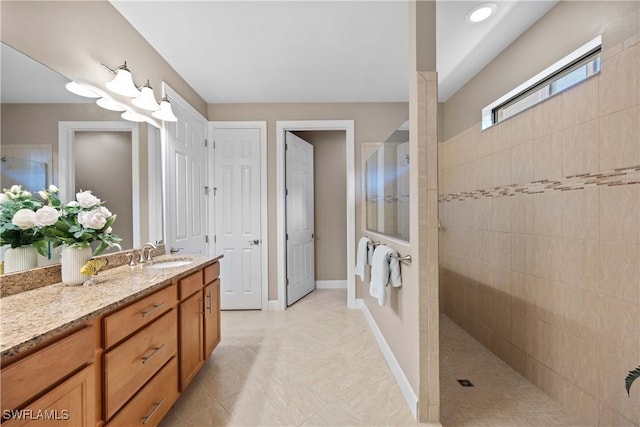 bathroom with vanity and a tile shower