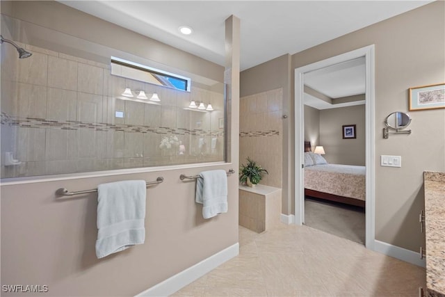 bathroom featuring tiled shower, vanity, and tile patterned flooring