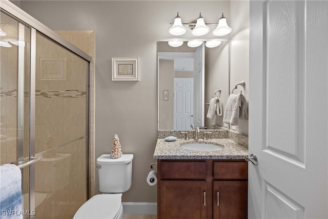 bathroom featuring vanity, an enclosed shower, and toilet