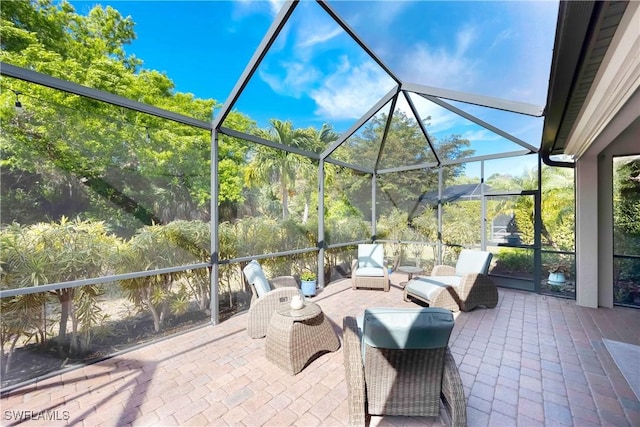 view of patio with area for grilling and glass enclosure