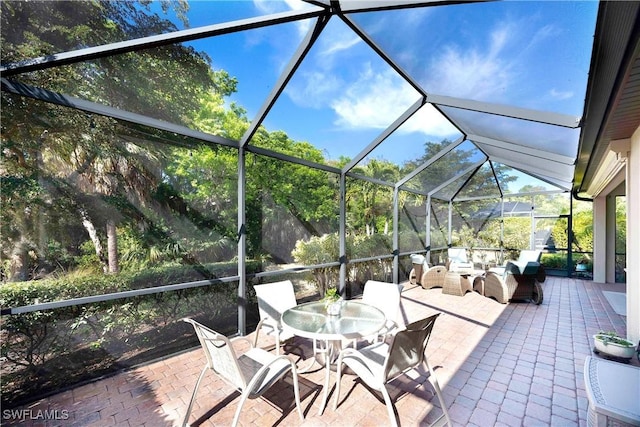 view of patio featuring outdoor lounge area and glass enclosure