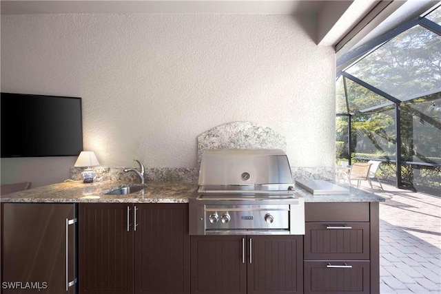 view of patio / terrace with a grill, a lanai, exterior kitchen, and sink