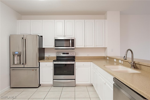 kitchen with stainless steel appliances, white cabinetry, sink, and light tile patterned floors