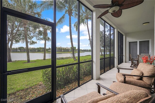 sunroom / solarium featuring a water view and ceiling fan