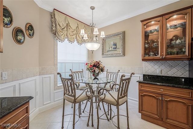 dining room with ornamental molding, a chandelier, and light tile patterned floors