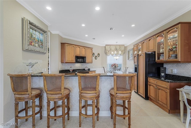 kitchen with refrigerator with ice dispenser, crown molding, light tile patterned floors, a breakfast bar, and decorative backsplash